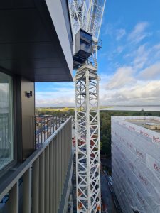 Tower crane used for the SlideOn installation of prefabricated balconies for residential schemes construction site.